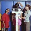 Fontbonne University > Gym teacher measuring and weighing students (12-14) on scale