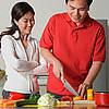 Fontbonne University > Couple in kitchen, man cutting vegetables, woman watching him